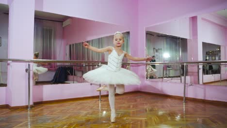 ballerina dansen in de studio voor de spiegel. in de balletzaal. een kleine danseres. slow motion.