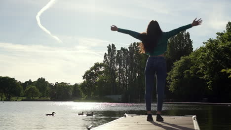 hermosa mujer italiana con los brazos levantados mirando la vista del atardecer sobre el lago