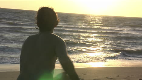 a man runs towards the ocean with a body board