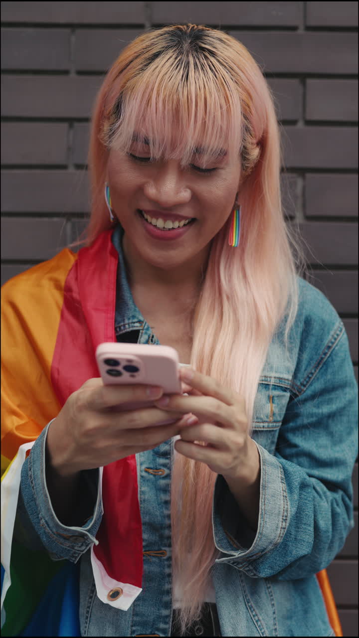 Persona che usa il telefono con una bandiera del Pride
