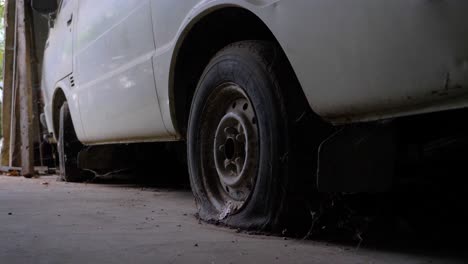 old white van with flat tires in a barn in french counstryside in slowmotion