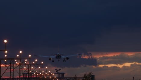 airplane landing at night with dramatic sunset sky