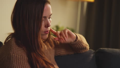 Close-Up-Of-Woman-Sitting-On-Sofa-At-Home-Using-Mobile-Phone-To-Check-Social-Media-Message-And-Scrolling-Online