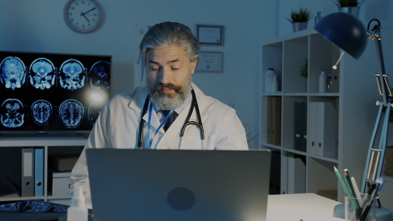 Doctor Working Late at Night on Laptop