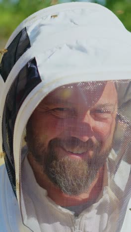 close-up of a beekeeper in protective suit surrounded by bees