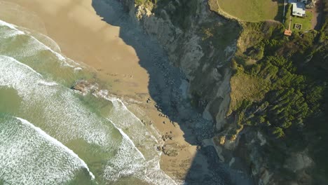 Aertial-view-of-the-Yaquina-Head-Lighthouse-beach-and-surrounding-mansions-in-Newport,-Oregon