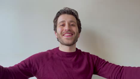 young male university student singing happy birthday directly to camera during video call