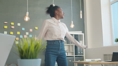 mujer feliz bailando en la oficina