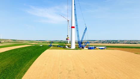 installation of wind turbine with huge crane - aerial drone shot