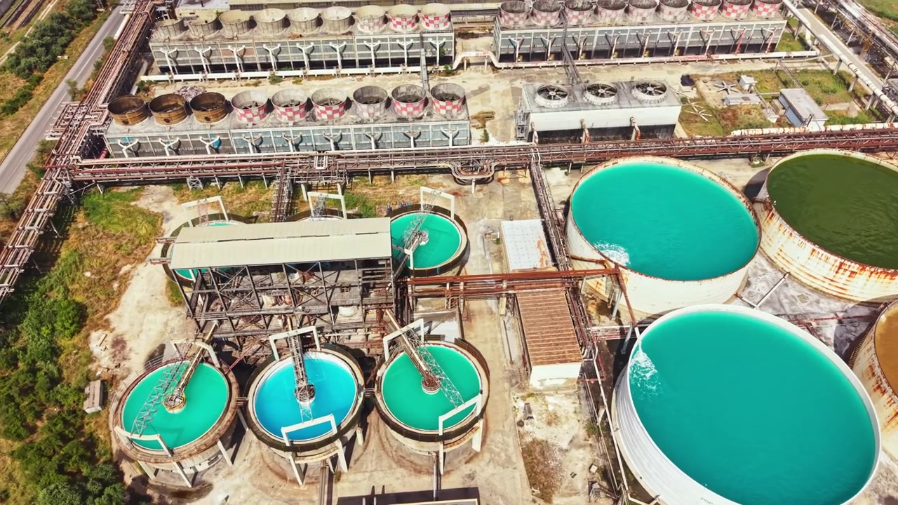 Industrial site with large water tanks and pipelines in daytime
