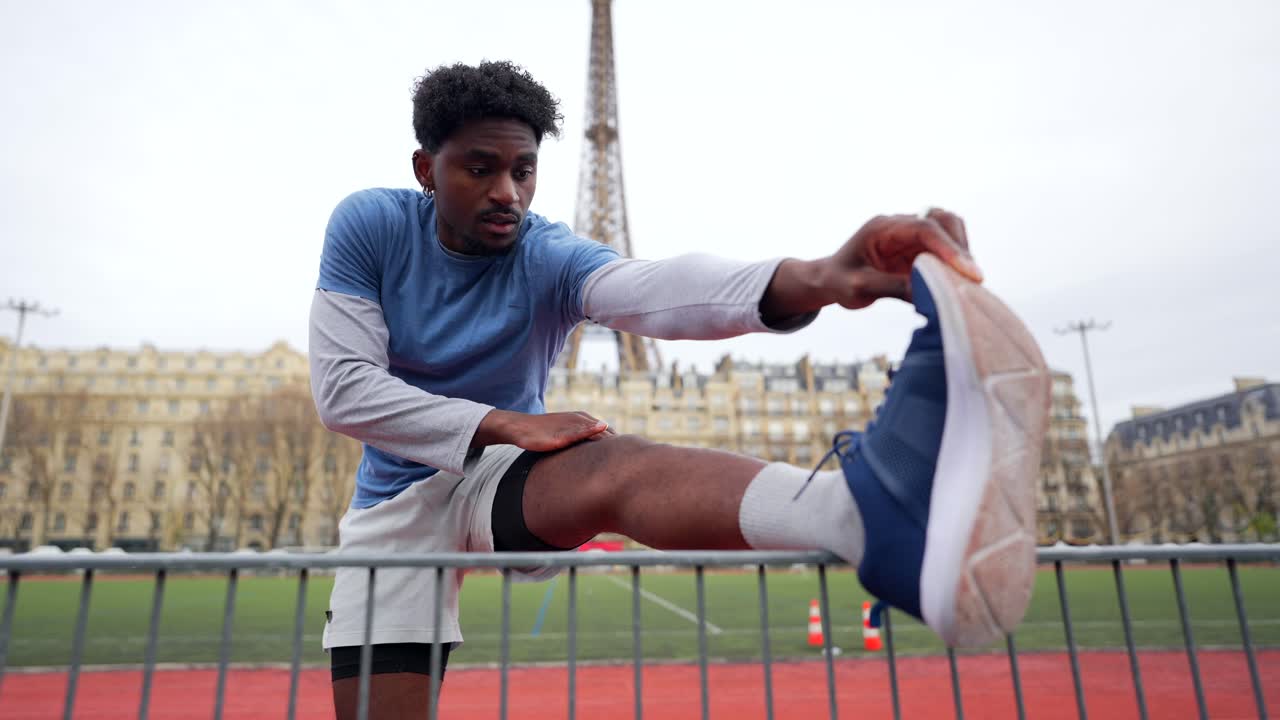 Uomo che si allunga vicino alla Torre Eiffel
