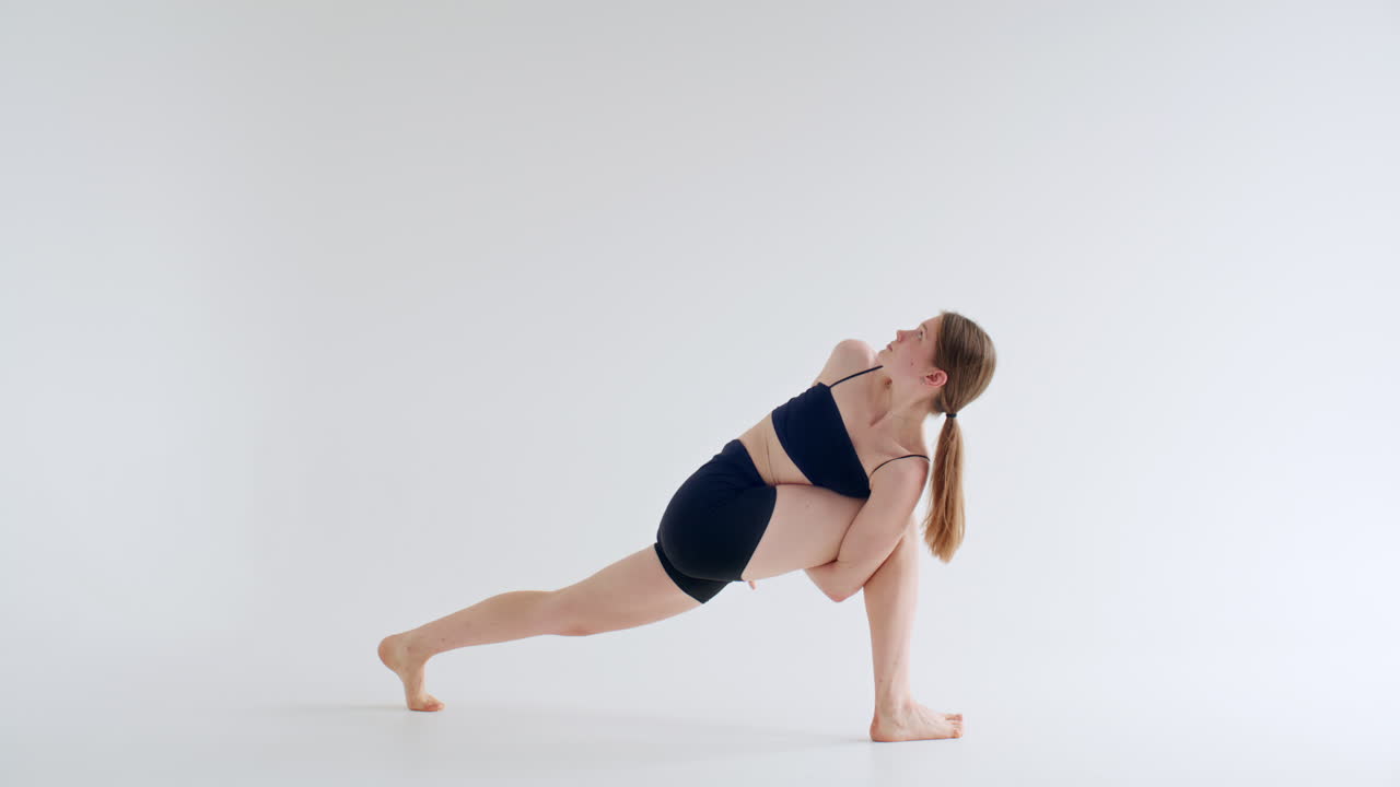 Young Woman Performing Revolved Bound Side Angle Pose during Yoga Practice