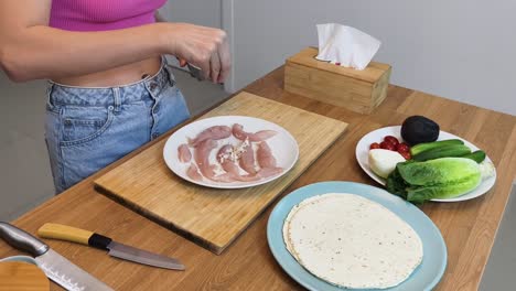 preparing a chicken wrap with vegetables