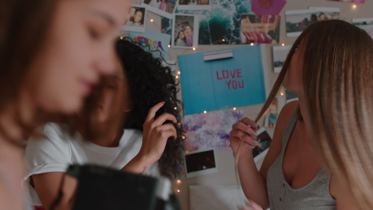 행복한 십대 소녀들이 즉각 사진 카메라를 사용하여 함께 사진을 찍고 가장 친한 친구들이 주말에 집에서 친구 관계를 즐기고 있습니다.