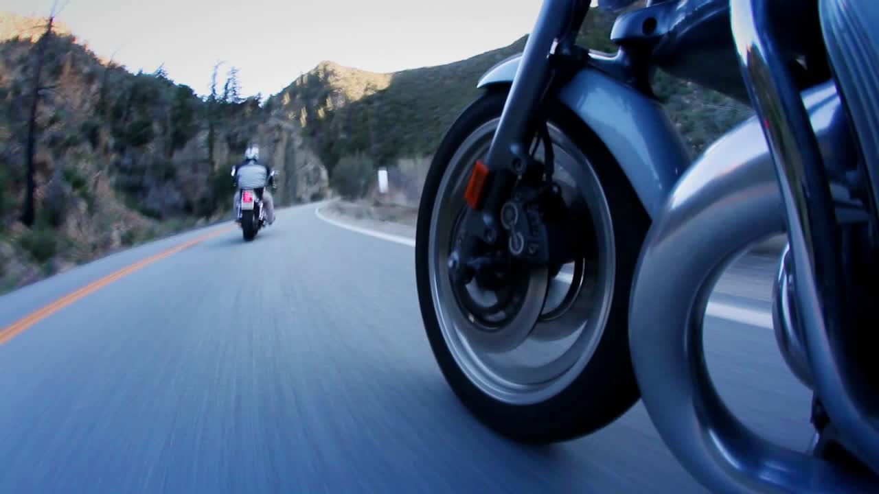 los motociclistas están bajando por una carretera de montaña