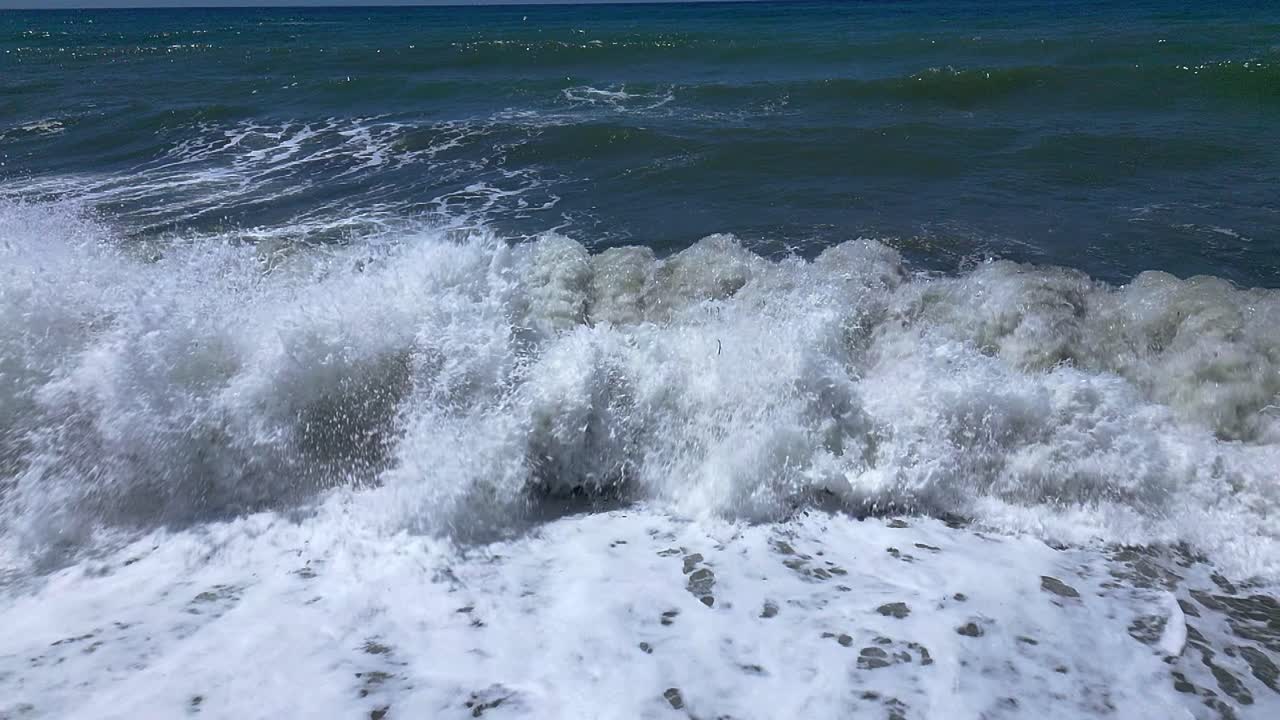 Crashing waves on the beach. Slow motion. Aerial view. Wave foam. Coastline. Andalusia. Spain.