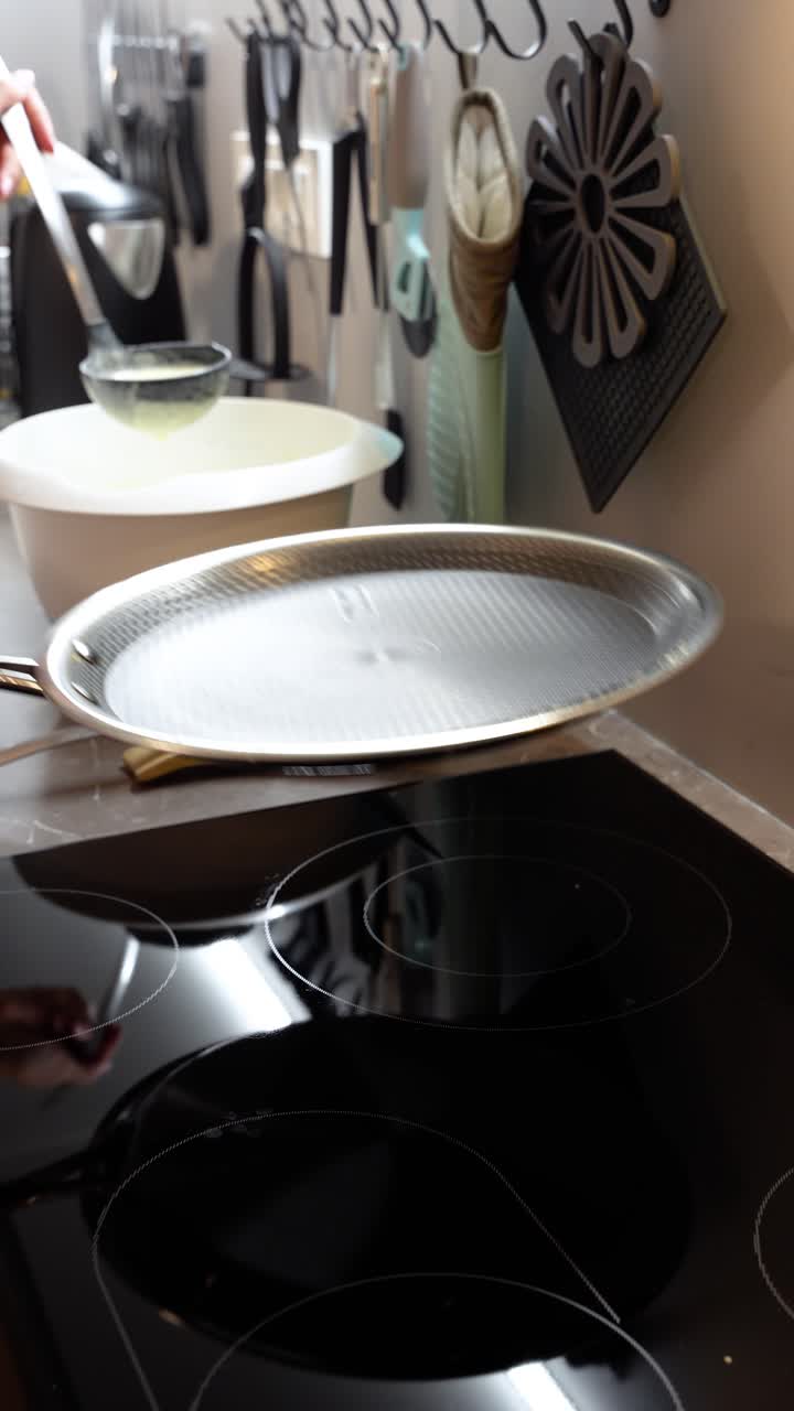 Batter poured into a pan, cooking European-style pancakes in a modern kitchen. Close-up food preparation concept with authentic homemade breakfast vibes