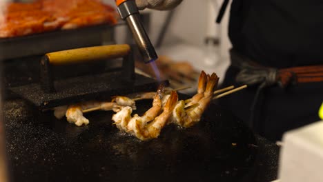 chef grilling shrimp over open flame