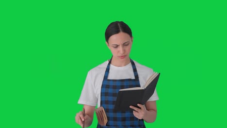 indian housewife making food from recipe book green screen