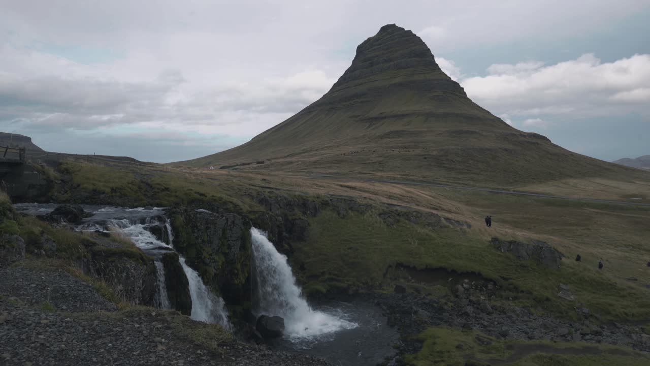 toma estática de una cascada con la montaña kirkjufell en islandia.