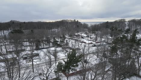 gimbal tilt while rising over a lakeshore neighborhood in michigan during a soft snowfall