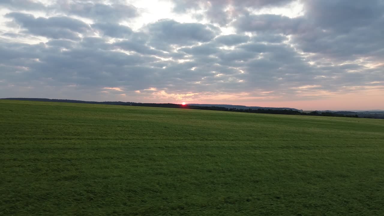 vista del avión no tripulado mientras vuela sobre el campo directamente hacia el sol naciente