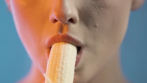 unrecognizable woman eating a banana, close up mouth detail