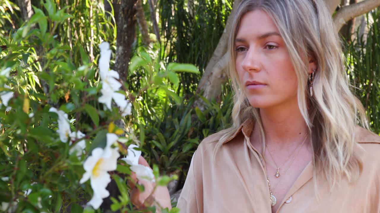 젊은 여자는 garden_slow 모션에서 꽃을 검사