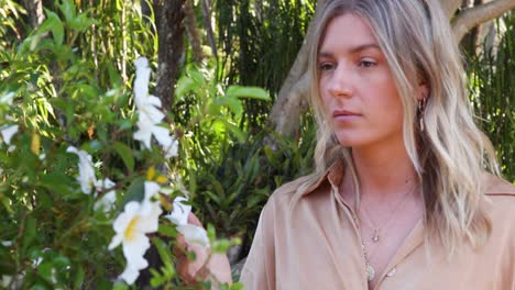 Young-woman-inspects-flowers-in-garden_slow-motion