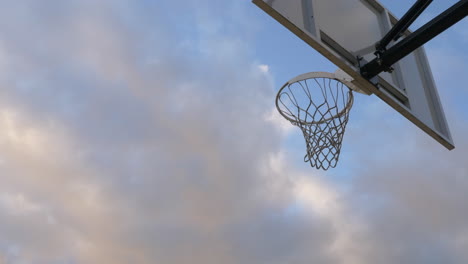 basketball player doing a reverse layup shot on the hoop in a basketball court