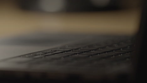 person typing on laptop keyboard at night