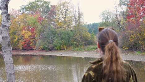 Mujer-Joven-Con-Vistas-Al-Río-Y-Los-árboles-De-Otoño