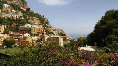 a slowly panning shot of a quaint italian village in summer with colorful plants and old architecture