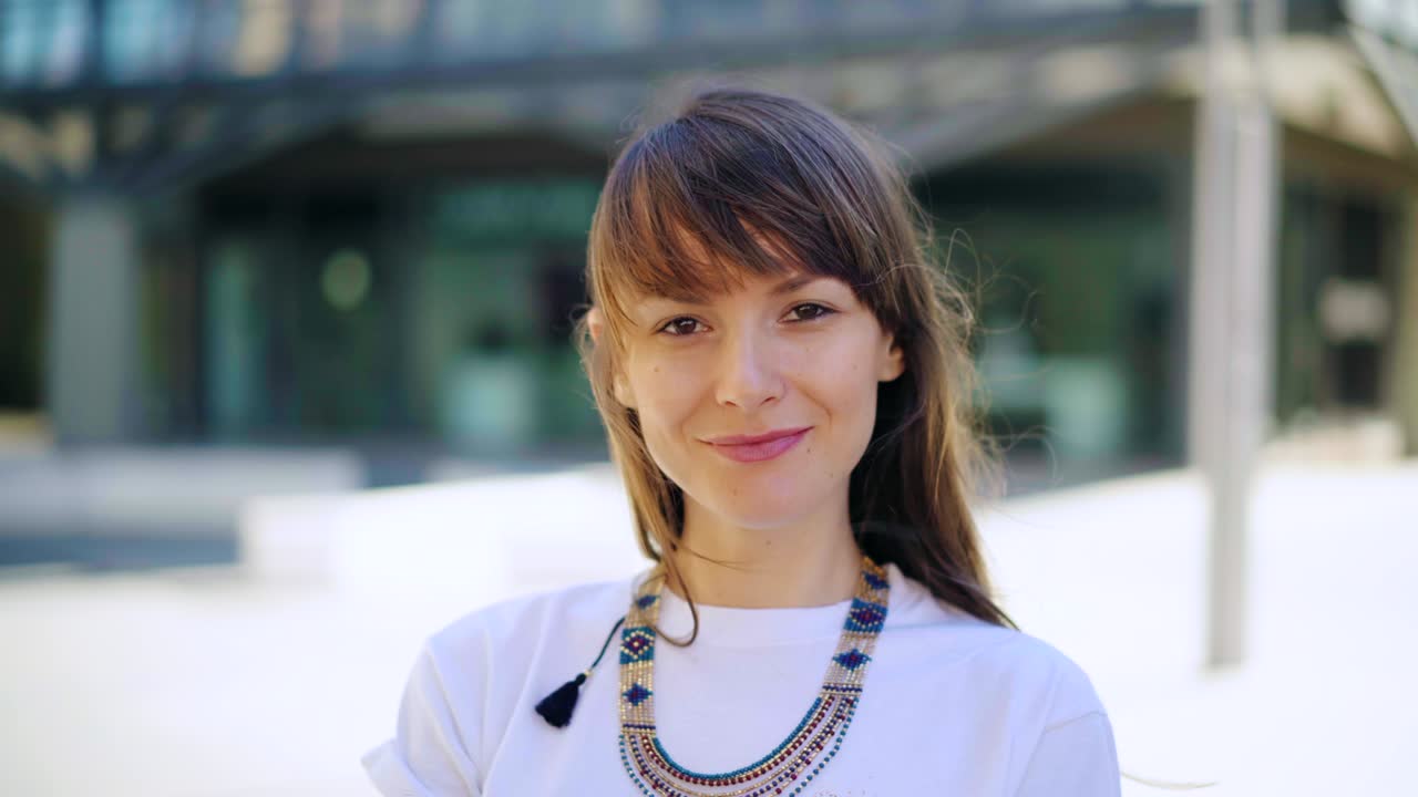 패셔널한 젊은 전문 여성의 초상화가 카메라를 바라보고 있습니다.