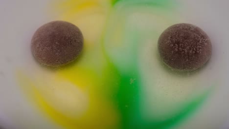caramelo redondo similar a una tableta, se disuelve en agua, liberando burbujas, primer plano