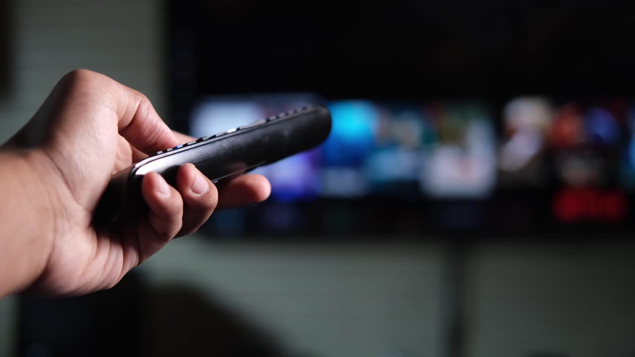 손으로 tv 리모컨을 들고