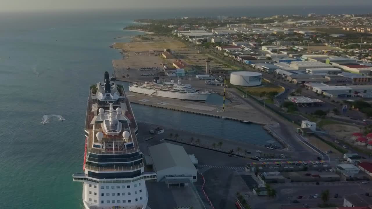 Aerial view of the cruise ship in dock with the camera tilting down to overview the blue water