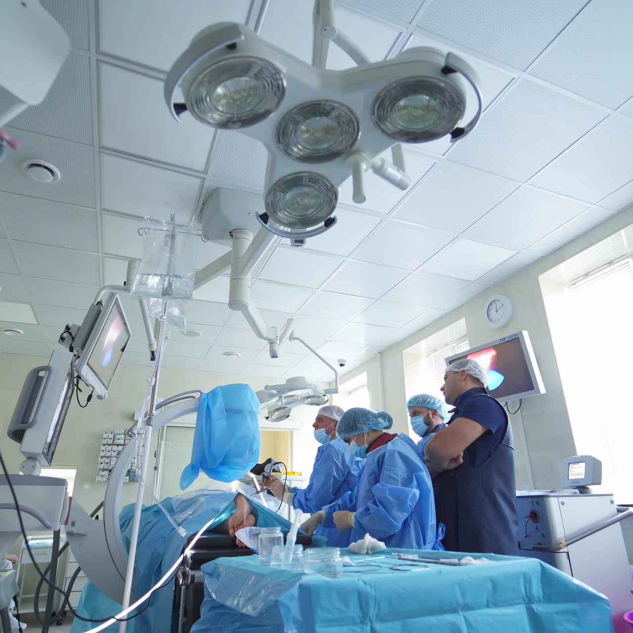 Operating room with surgery in progress. Medical team performing surgical operation in bright modern operating room