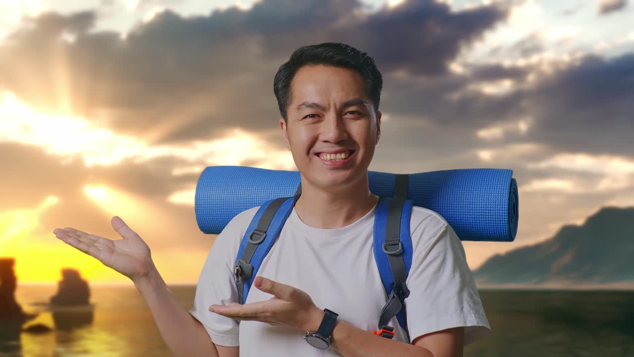 Close Up Pendaki Pria Asia Dengan Ransel Gunung Tersenyum Dan Menunjuk Ke Samping di Pantai