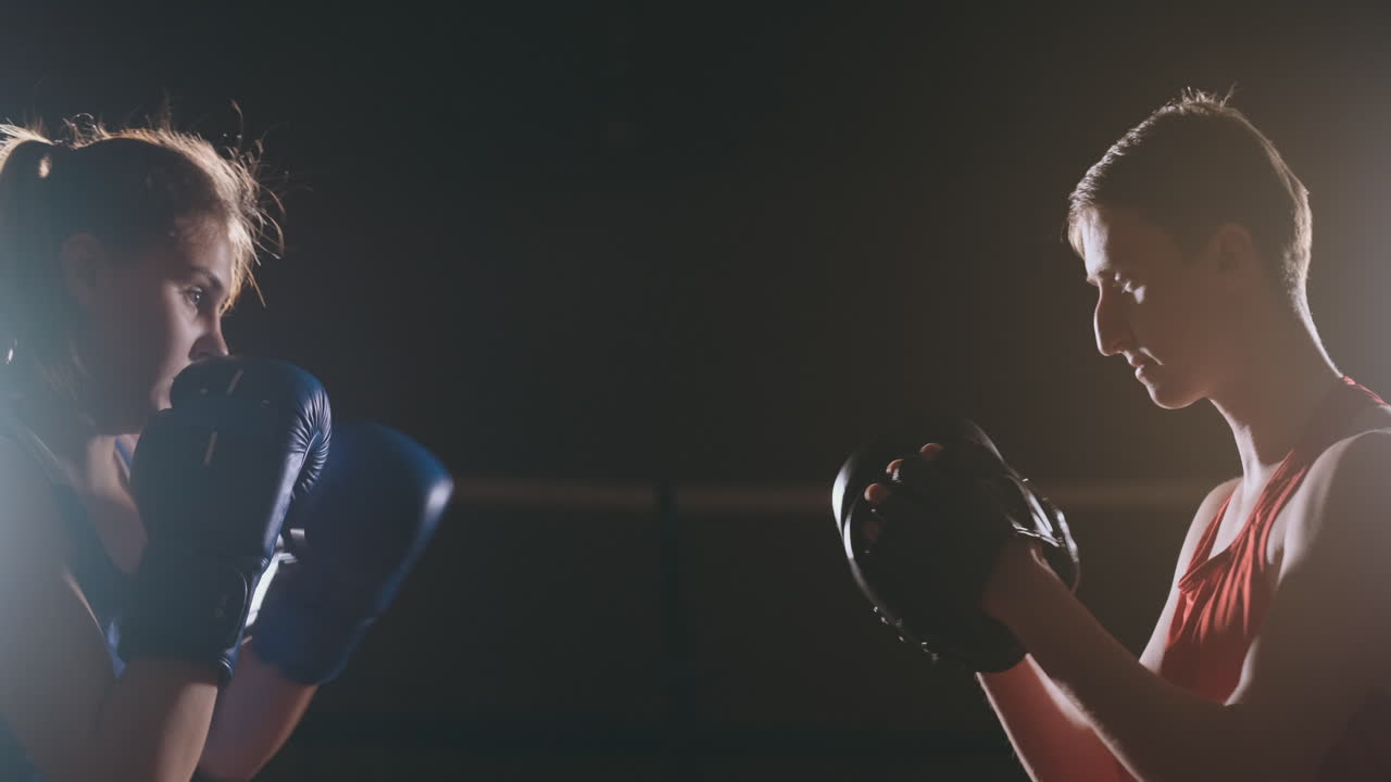 mujer deportista de acondicionamiento físico boxeo golpes enfoque guantes disfrutando de ejercicio intenso mujer luchadora entrenando amiga en el gimnasio entrenando juntos en cámara lenta