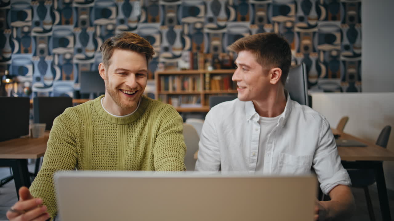 Smiling workers speaking virtual meeting in modern office. Businessmen talking