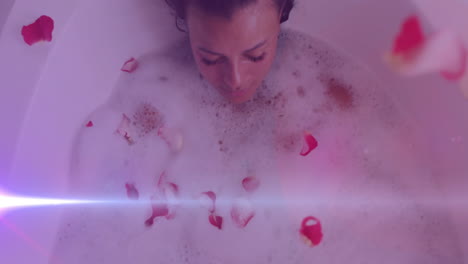animación de puntos de luz sobre una mujer caucásica tomando un baño con pétalos