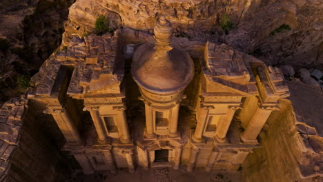 aerial view of ad deir monastery building carved out on rocks in petra, jordan