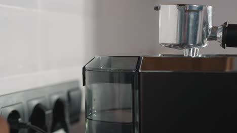 dama cierra el tanque de agua de la cafetera en el primer plano de la cocina. mujer finaliza el mantenimiento del fabricante antes de preparar una bebida aromática en casa. bebida casera