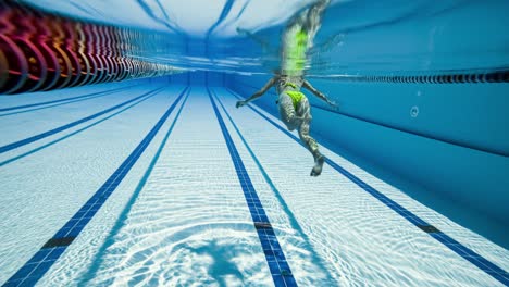 mujer nadando en la piscina en la piscina olímpica vista desde debajo del agua