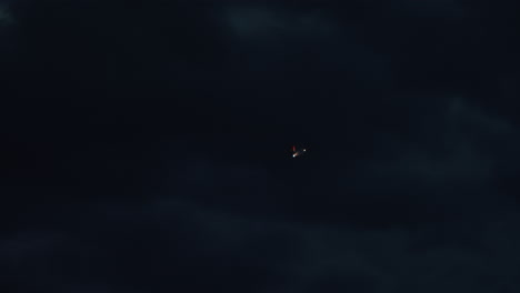 airplane flying through dark clouds at night