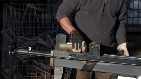 Log-cutting-machine-chopping-wood,-Caucasian-man-preparing-for-cold-winter,-medium-close-shot