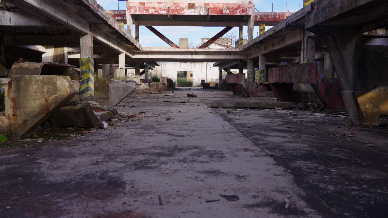 Vista interna di un edificio industriale in cemento abbandonato e diroccato