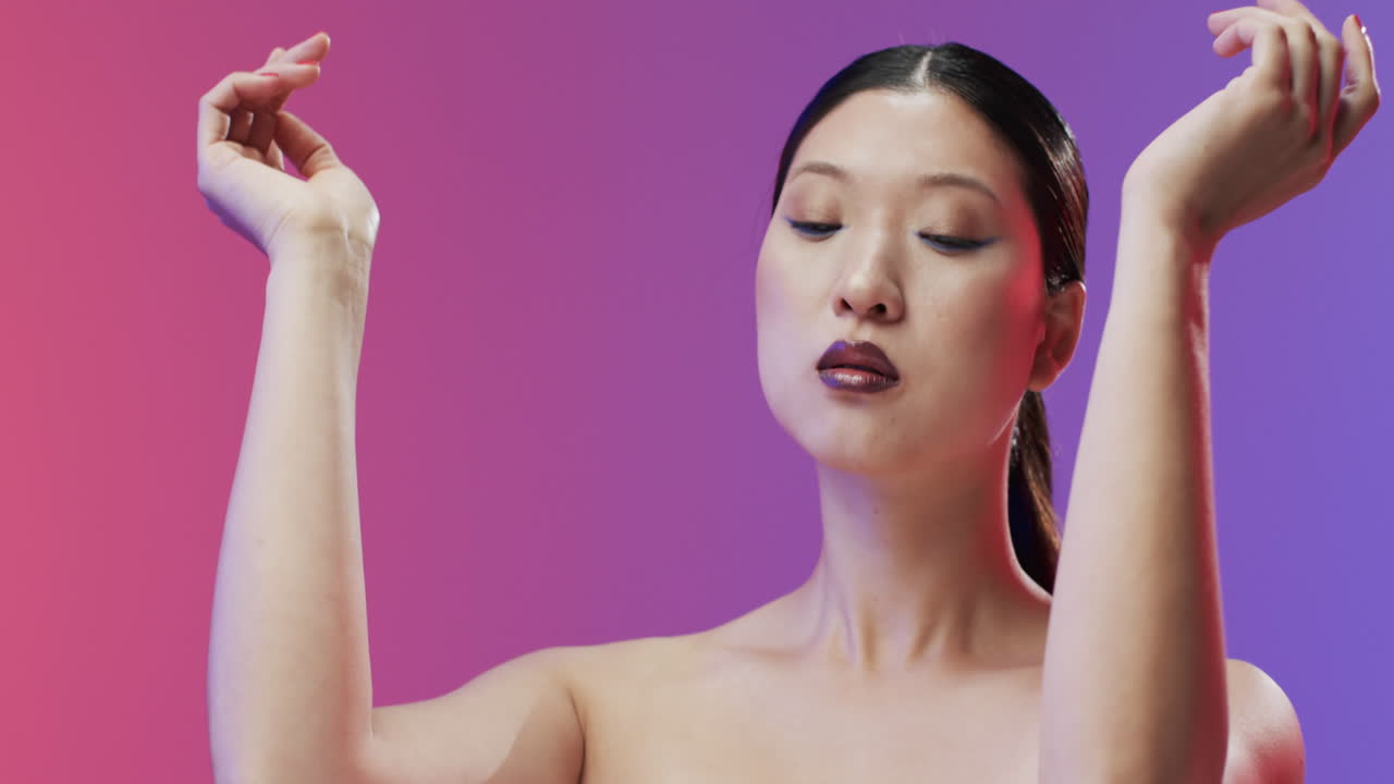 검은 머리카락, 은 입술과 메이크업을 가진 아시아 여성 카메라를보고, 복사 공간, 느린 동작