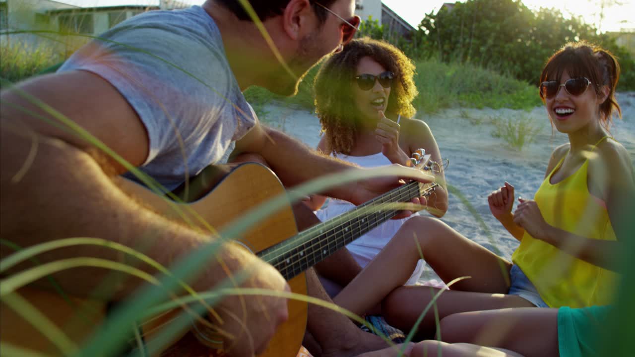 estudiantes multiétnicos divirtiéndose en un picnic en la playa